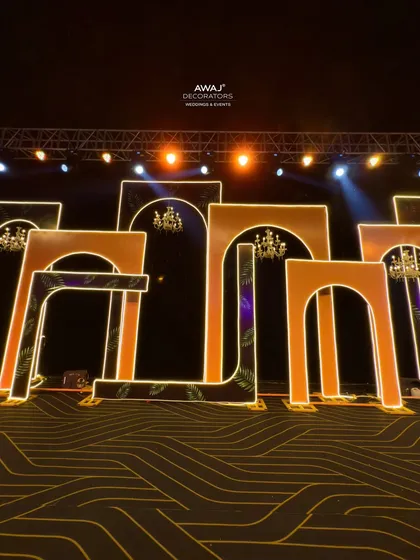 The Sangeet stage from a low angle, emphasizing the scale of the geometric, illuminated arches.