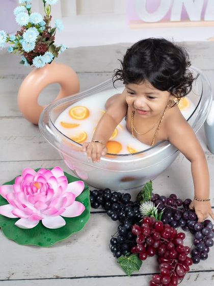 This little one is reaching for more grapes to add to her fruity bath.