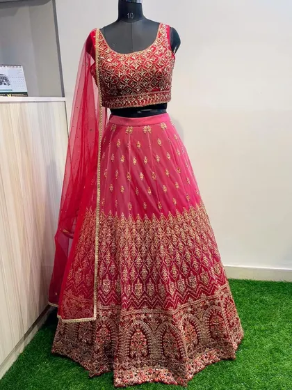 A full view of the classic pink wedding guest lehenga. It's a complete set with a matching net dupatta, ready for you to rent and flaunt.