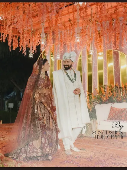 A stunning portrait of Nidhi and Alok under their wedding decor. The way they look at each other captures the essence of their deep connection and happiness.