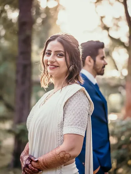 A beautiful, soft-focus shot of the bride smiling towards the camera while her partner stands behind her. It’s a moment of quiet confidence and happiness.
