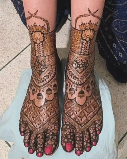 A stunningly detailed foot design with lotus motifs and jhumkas, perfect for a bride.