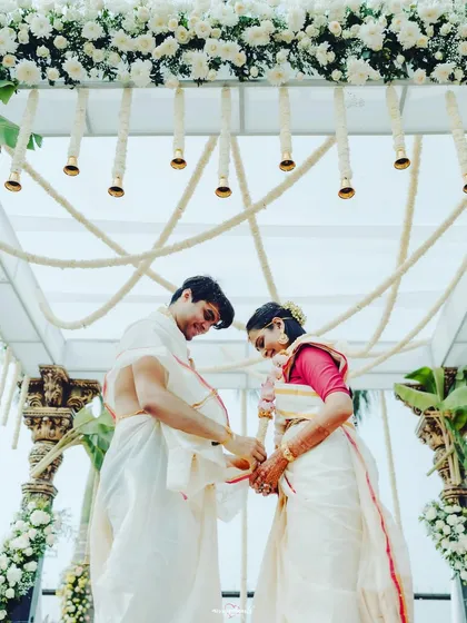 The couple tying the sacred knot, a symbolic and emotional moment framed by the elegant white floral mandap.