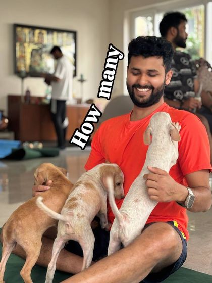 A smiling participant has his lap full of three happy puppies, showcasing the abundance of love at our events.