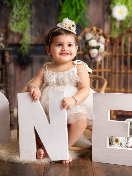 Celebrating the big ONE! This classic first birthday portrait with rustic decor and beautiful flowers is perfect for capturing your baby at this important milestone.
