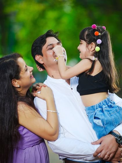 A playful and candid moment where a daughter lovingly teases her father during their family's outdoor photoshoot.