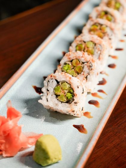 This vegetarian sushi roll is filled with crisp asparagus and other fresh vegetables, then drizzled with a sweet soy glaze. It is a simple, elegant, and delicious choice.