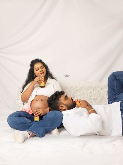 A fun and relaxed pose with the couple enjoying a drink together. This shows that maternity shoots can be playful and reflect your personality.