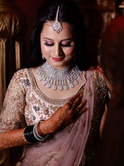 For her reception, we chose a soft and romantic look. The makeup features shimmery pink eyeshadow and a matching lip, which looks beautiful with her pastel pink lehenga and diamond jewellery.