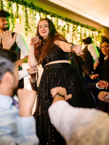 A guest takes center stage on the dance floor, surrounded by friends in a moment of pure fun.