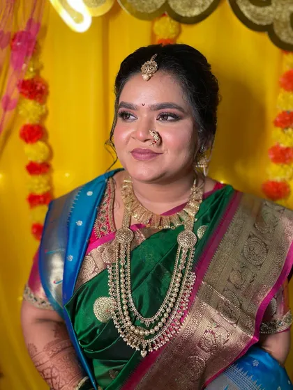 A beautiful look for the wedding ceremony, with soft makeup that complements the bride's green and blue saree.