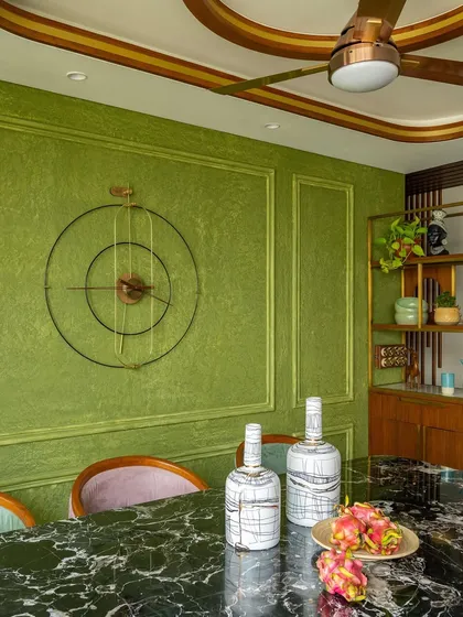 A detail of the dining room, showing the custom minimalistic clock against the textured green wall.