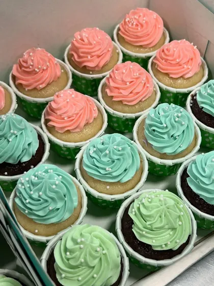 Adorable pink and teal cupcakes for a baby shower. These simple swirls with a sprinkle of white nonpareils are perfect for celebrating a new arrival.
