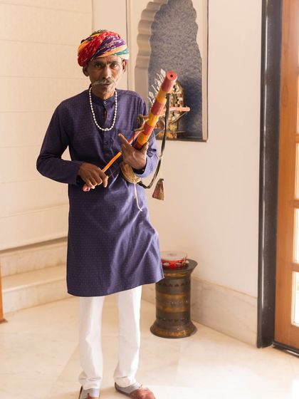 A traditional folk musician playing a stringed instrument. Incorporating local and traditional artists is a wonderful way to add cultural richness and a unique flavor to a wedding celebration.