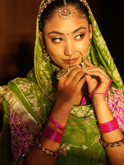 A candid shot capturing the beauty of the Rajasthani bridal makeup. The warm tones on the eyes and the traditional nath (nose ring) are key details our students perfected.