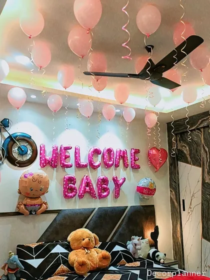A close-up of the "Welcome Baby" balloon arrangement over the bed. The mix of foil and latex balloons adds variety and visual interest to the simple and sweet setup.