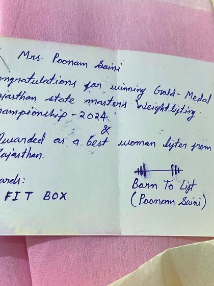 The congratulatory note for winning the gold medal and being awarded Best Woman Lifter. The details matter.