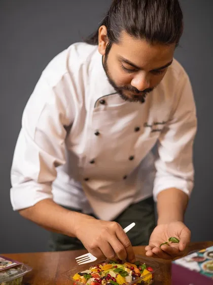 As the founder, I personally ensure the quality of every dish. Here I am adding the final touches to our fruit salad, a dish that embodies our philosophy of fresh and healthy eating.