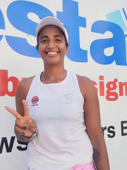 Riya Bhatia flashes a victory sign after her pre-quarterfinal win at the Fenesta Open, advancing to the next round with a solid performance.