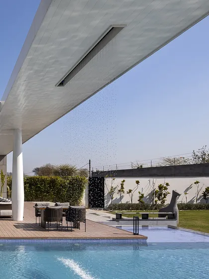 At our 'Ananda' project, we designed a unique water feature that creates a curtain of rain falling from the roof overhang into the swimming pool. This element adds a dynamic sensory experience to the backyard, combining the soothing sound of water with a stunning visual effect.