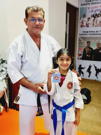 An instructor proudly stands with a young medalist. Our teaching team is dedicated to helping every student reach their full potential.