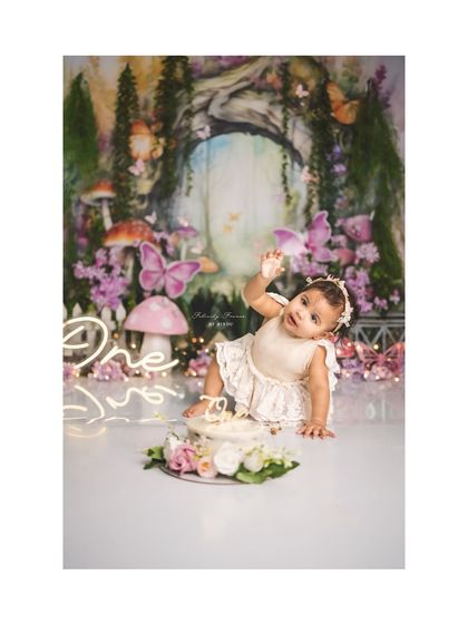 A little fairy having a blast during her cake smash. The joy and mess are what make these sessions so memorable.