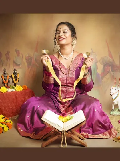 A woman engrossed in devotion, playing cymbals during our Ashadhi Ekadashi themed studio session.