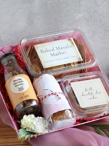 A handcrafted arrangement for the special ladies in your life. This pink tray hamper includes Baked Masala Mathri, Chunky Chocolate Granola, and Double Chocolate Chip Cookies.
