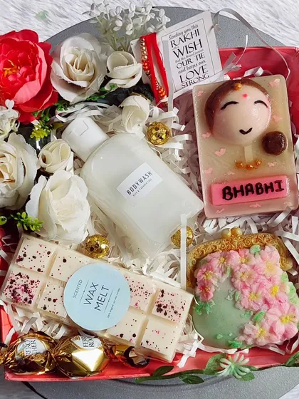 A gorgeous Rakhi hamper for a bhabhi. It includes a personalized "Bhabhi" soap, a floral purse soap, body wash, wax melts, and chocolates.