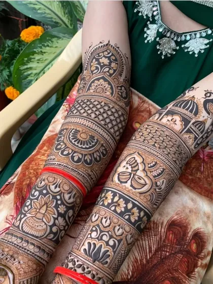 A close-up of a forearm adorned with a palace dome, peacock, and a sacred kalash, all classic elements of a traditional bridal mehendi.