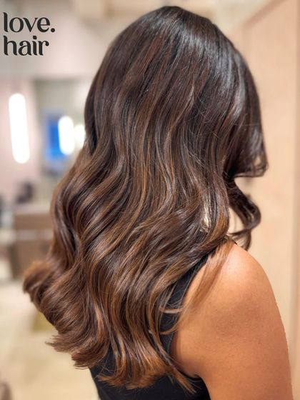 A decadent chocolate lava look. This balayage features deep, rich chocolate tones melting into slightly lighter ends, creating a subtle and luxurious gradient.