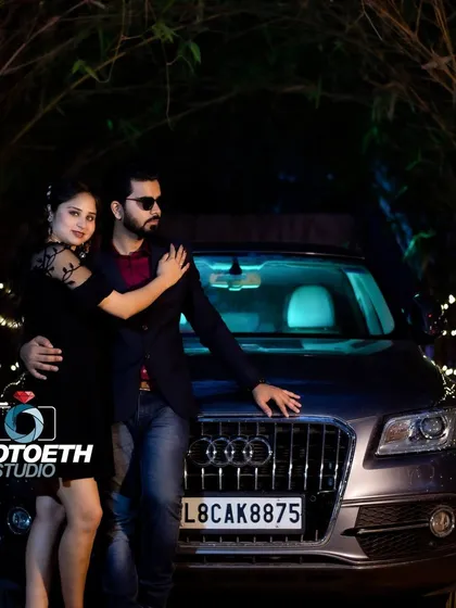 For a sleek and modern pre-wedding shoot, we can incorporate a luxury car like this Audi. The dark, moody lighting and the couple's confident pose create a powerful and stylish image.