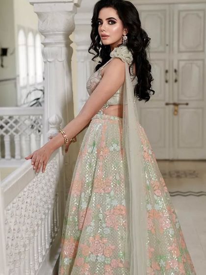 A side profile of a client in the pastel floral lehenga, showing how the light catches the delicate sequins.