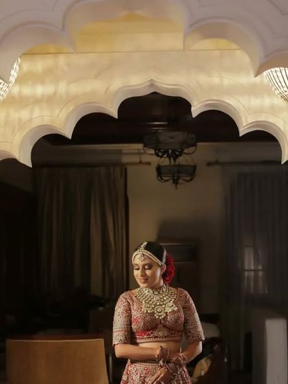 A serene bridal portrait under a beautifully carved archway. We find architectural details in the venue that complement the bride's elegance.