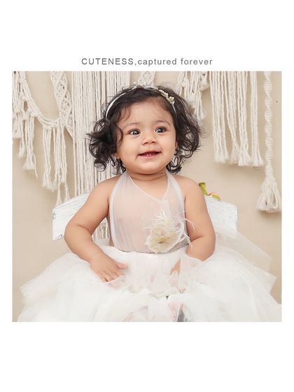 A sweet smile captured in a simple, boho-chic setting. The neutral tones and natural textures create a warm and inviting portrait.