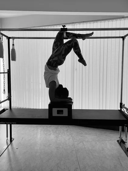 An artistic black and white photo of a forearm stand on the Cadillac box, a pose that requires immense core stability.
