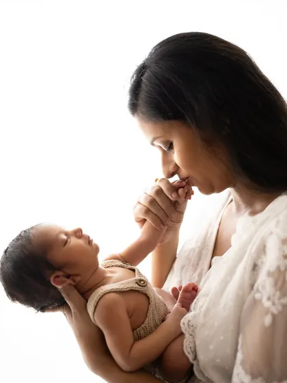 A mother's kiss. This timeless pose captures the deep, instinctual love between a mom and her newborn.