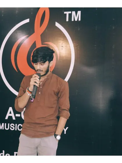A young man confidently singing into the microphone at one of our music events. My vocal coaching covers microphone technique and stage presence.