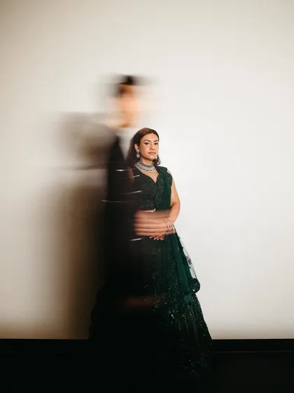 An artistic motion-blur portrait of the bride, with the groom as a passing silhouette, creating a sense of fleeting, beautiful moments.