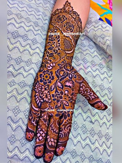 A single-hand view of a heavy bridal design, showing the combination of roses, leaves, and checkerboard fills for a rich texture.