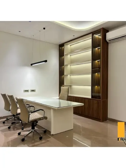 This executive office combines rich wood tones with modern, clean lines to create a space that feels both authoritative and stylish. The integrated back-lit shelving provides functional storage while adding a layer of ambient light and sophistication to the room.
