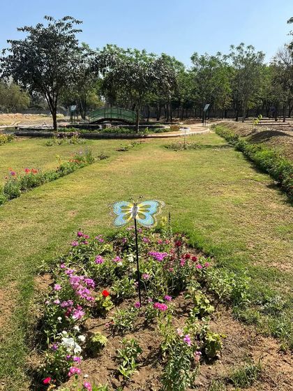 A view of a flower bed within the Butterfly Park, complete with a decorative butterfly marker. We planted a specific mix of nectar-rich flowers to create a welcoming habitat.