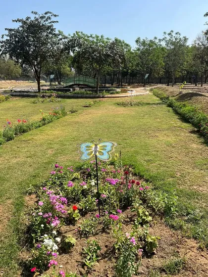 A view of a flower bed within the Butterfly Park, complete with a decorative butterfly marker. We planted a specific mix of nectar-rich flowers to create a welcoming habitat.