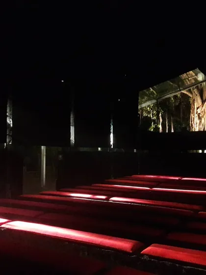 For the India Arch Dialogue exhibition, we created a dark pavilion where thin slits of light illuminate red seating. A single, large opening frames the banyan tree outside like a living painting.
