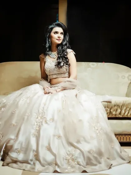 An elegant, posed portrait of the bride on a classic sofa.