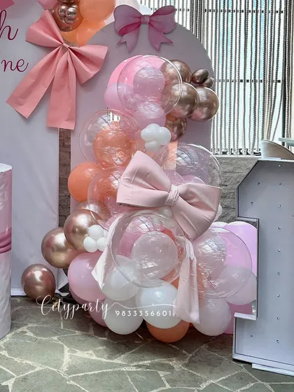 A bow-themed balloon arrangement for a girl's first birthday. We used a mix of pink, rose gold, and transparent balloons, incorporating large fabric bows directly into the design.