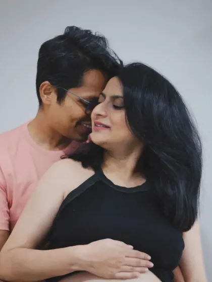 A tender and loving embrace captured at home, showing the comfort and intimacy of the couple as they await their baby.
