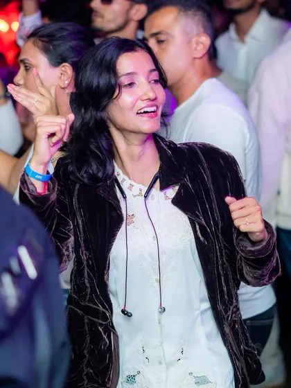 A candid shot of a guest smiling and dancing at the White Party. Our goal is to create genuine moments of happiness and connection.