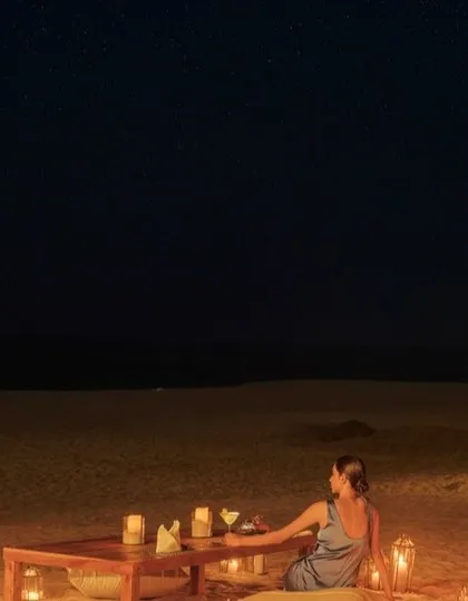 A romantic beach dinner setup under a starry sky at The Postcard Arabian Sea, perfect for an intimate and unforgettable evening.