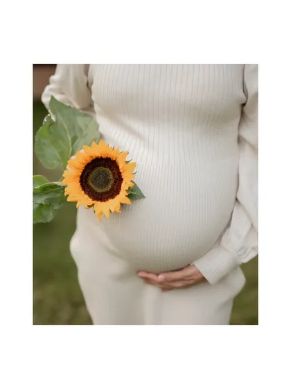 Using a single sunflower as a prop, this artistic baby bump photo adds a touch of brightness and nature to the portrait. It's a simple yet powerful way to celebrate your pregnancy.